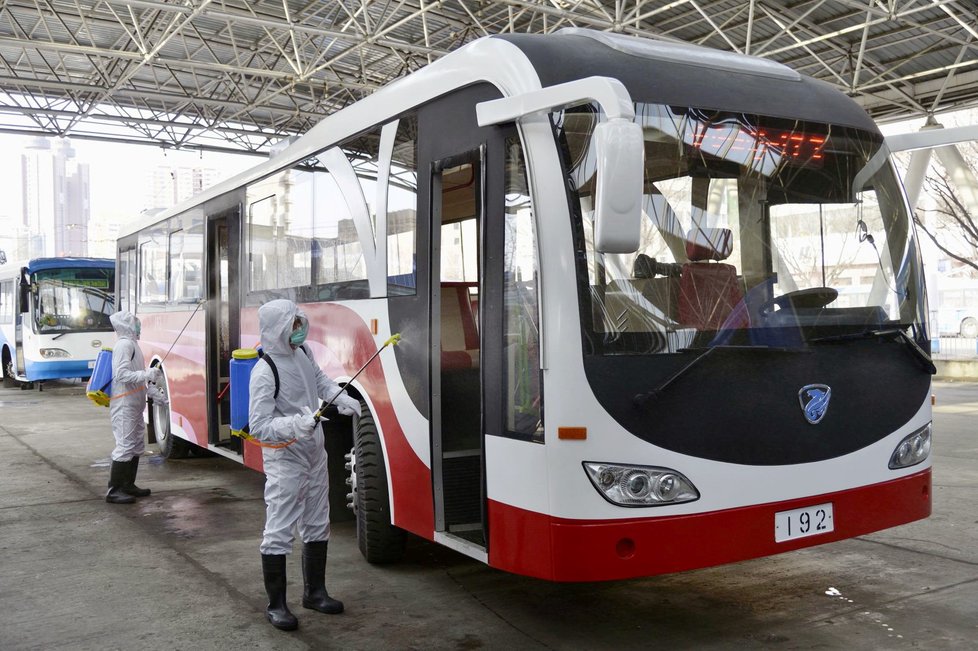 Pracovníci dezinfikují autobus v Pchjongjangu v KLDR.