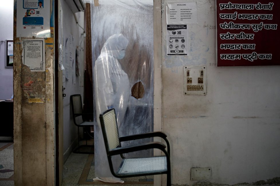 Koronavirus v Indii: Záběry z místního zdravotního střediska, kde lékaři vyšetřují pacienty skrz igelitový závěs.