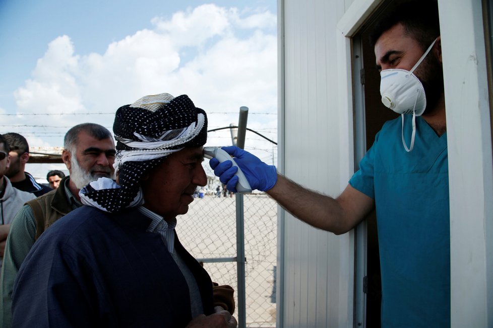 Irácké zdravotnické týmy měří teplotu na hranicích země u Erbilu.