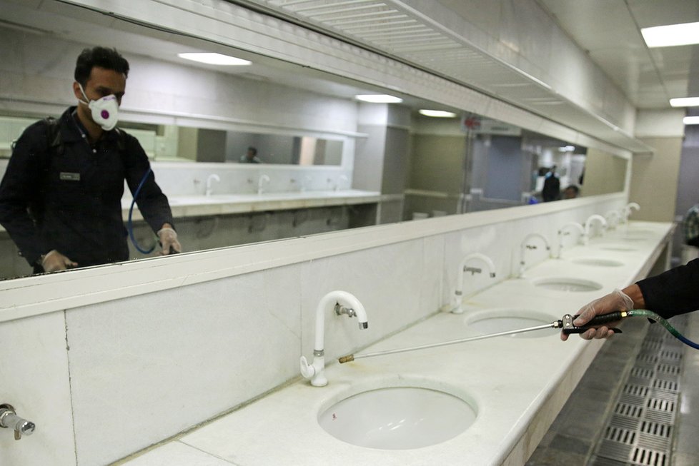 Pracovníci dezinfikují koupelnu ve svatyni Imama Rézy v íránském Mašhadu (29.2.2020)
