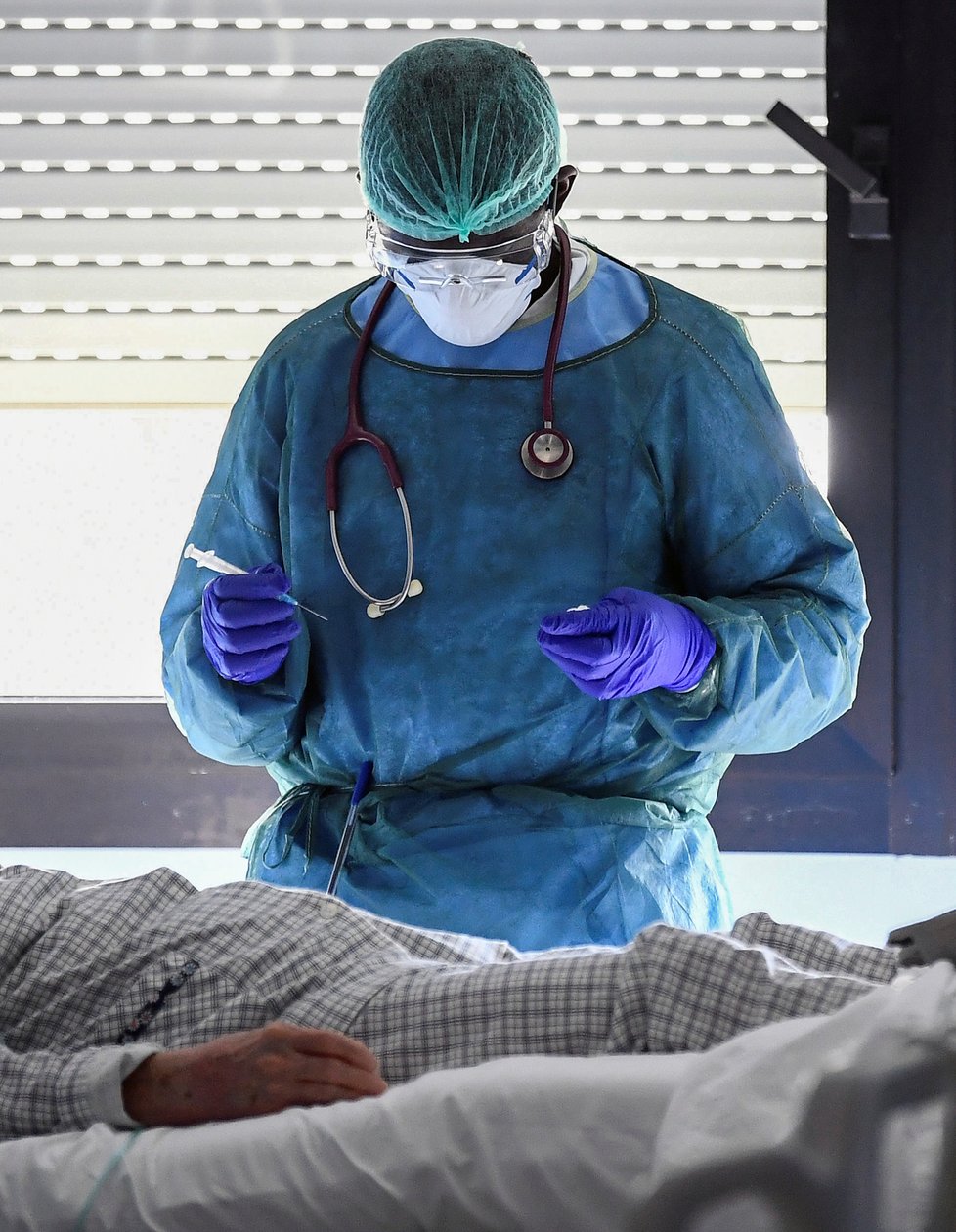 Během pandemie koronaviru platí přísná bezpečnostní a karanténní opatření po celém světě. Na snímku pacienti a zdravotníci z nemocnice v severoitalské Cremoně (19. 03. 2020).