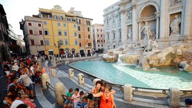 Turisté se fotí u slavné fontany Di Trevi v Římě.