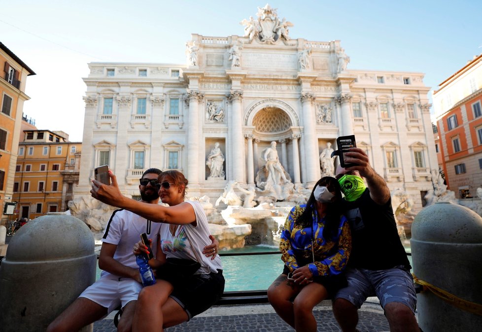 Turisté se fotí u slavné fontány Di Trevi v Římě.