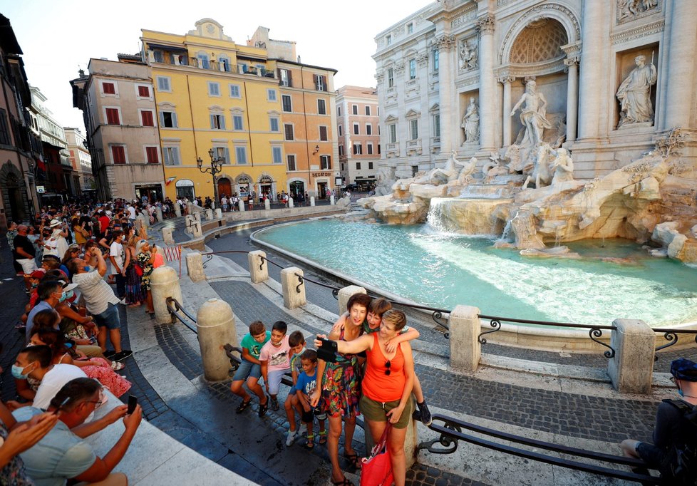 Turisté se fotí u slavné fontány Di Trevi v Římě.