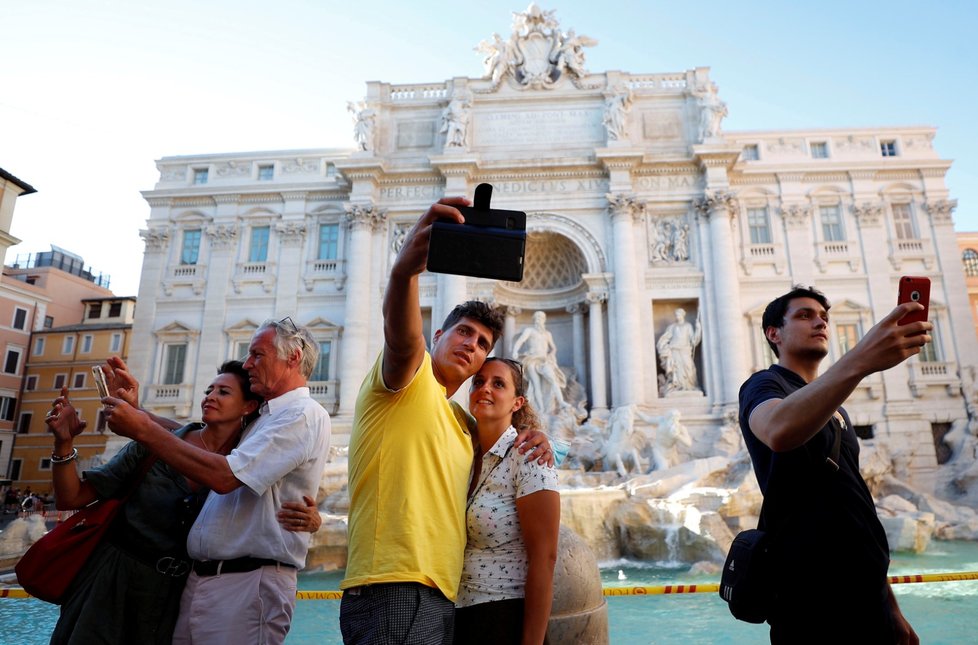 Turisté se fotí u slavné fontany Di Trevi v Římě.