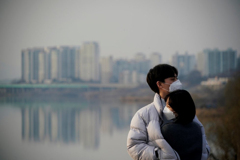 Lidé s rouškami u řeky Han v Jižní Koreji