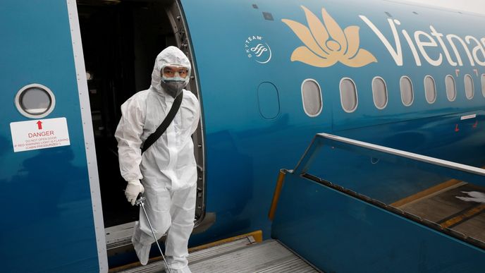 Pracovník letiště stříká desinfikační sprej na interiér letadel vietnamské aerolinky (Vietnam Airlines)