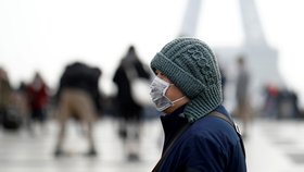 Lidé před Eiffelovou věží se chrání rouškami. Riziko nákazy koronavirem už hrozí i ve Francii (25. 1. 2019)