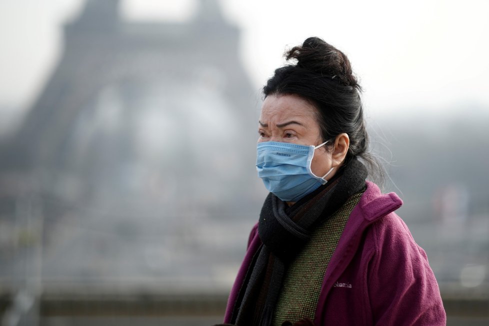 Lidé před Eiffelovou věží se chrání rouškami. Riziko nákazy koronavirem už hrozí i ve Francii. (25. 1. 2019)