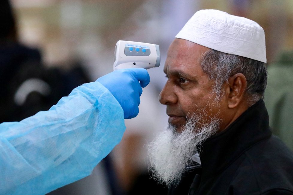 Lékaři měří teplotu pasažérům na letišti v Bangladéši (11.3.2020)