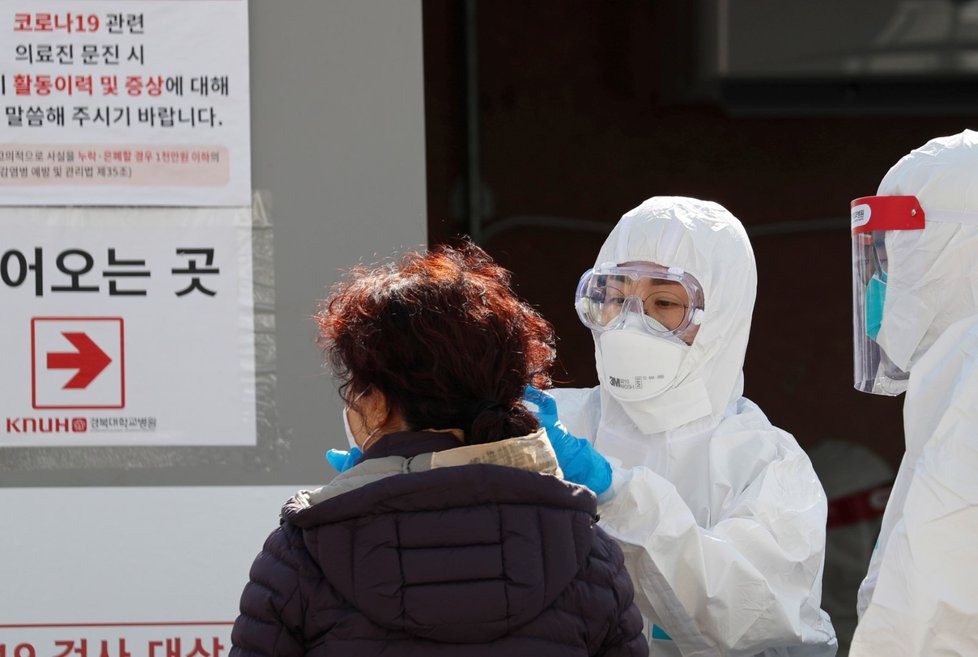 Lékař měří teplotu ženě v jihokorejském Daegu (5.3.2020)