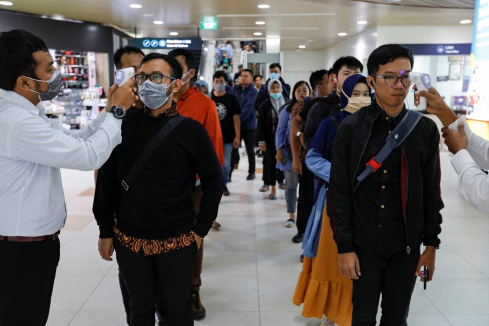 Lékaři měří teplotu pasažérům hromadné dopravy v indonéské Jakartě (5.3.2020)