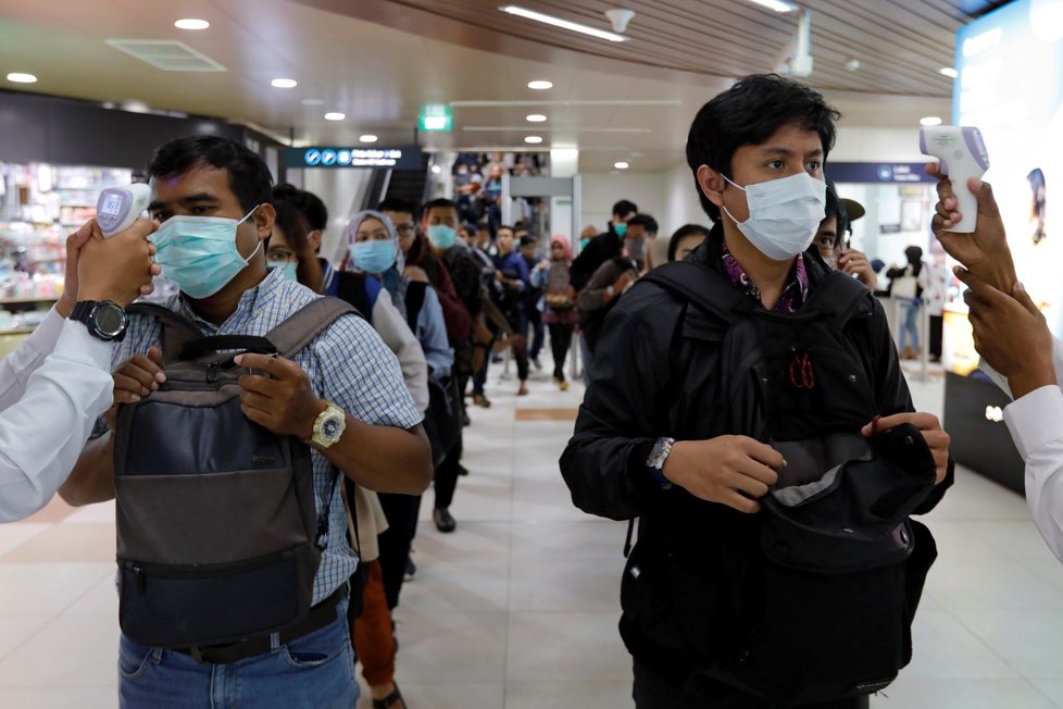 Lékaři měří teplotu pasažérům hromadné dopravy v indonéské Jakartě (5.3.2020)