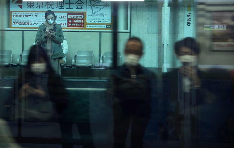 Žena s rouškou čeká na vlak v Tokiu v Japonsku (5.3.2020)