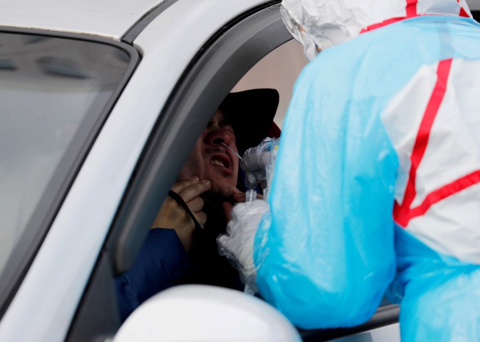 Lékaři vyšetřují řidiče v „drive-through“ klinice, která testuje příznaky nemoci COVID-19 (3.3.2020).
