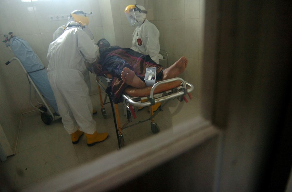 Lékaři nakládají do sanitky pacienta s podezřením na nákazu koronavirem v Indonésii. (11.3.2020)