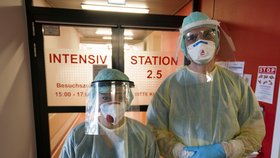Koronavirus v Německu, sestry v ochranných oděvech před jednotkou intenzivní péče.