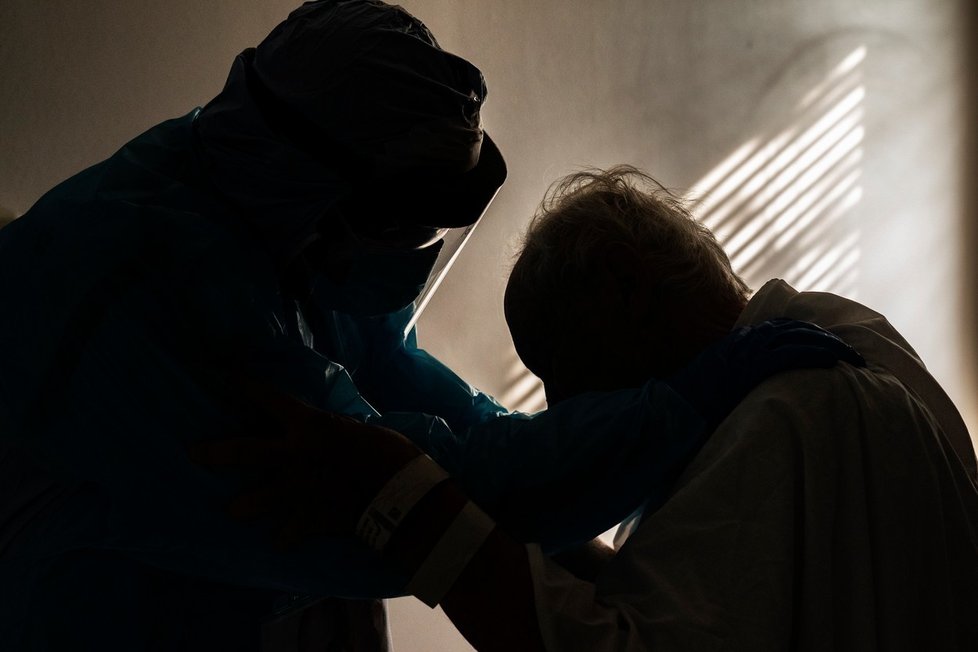 Dojemný snímek lékaře utěšujícího pacienta s koronavirem: Starší lidé izolaci snáší nejhůře