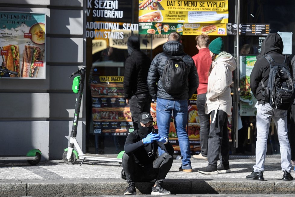 Lidé čekají u okénka občerstvení s bagetami v centru Prahy. Restaurace jsou od 14. března uzavřeny kvůli opatření vlády proti šíření koronaviru, prodej z výdejního okénka je povolen. (14. 3. 2020)