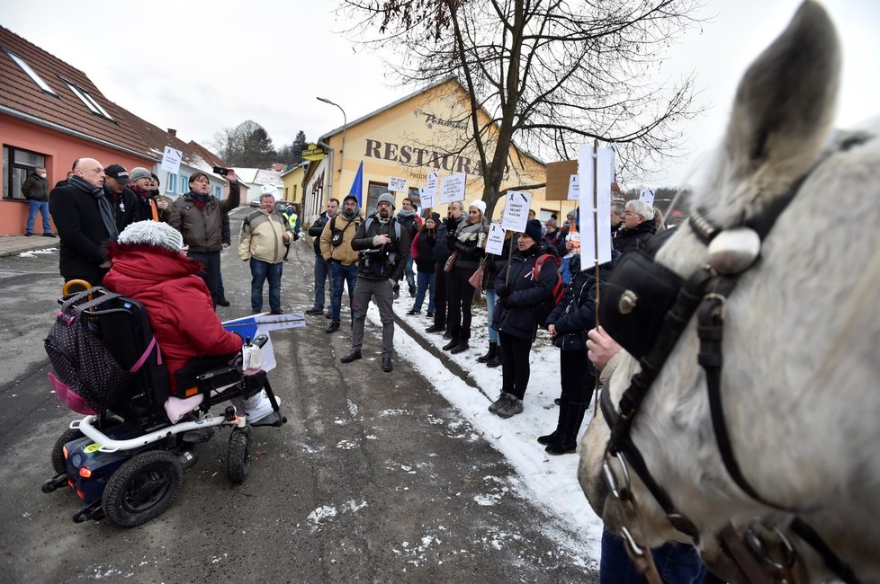 Desítky lidí s transparenty, českými i černými vlajkami, koňmi a rakví se dnes odpoledne vydaly k domu ministra zdravotnictví Jana Blatného (za ANO) v Jinačovicích na Brněnsku.