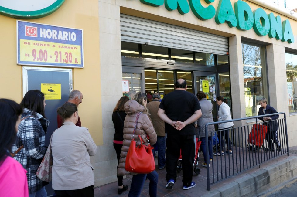 Ve Španělsku se tvoří dlouhé fronty před vstupem do místního supermarketu, lidé nadále skupují potraviny ve velkém.