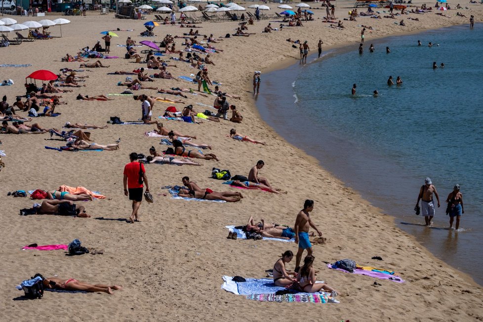 V Barceloně se s teplým červnovým počasí zaplnily pláže, lidé by na nich měli dodržovat rozestupy 1,5 metru