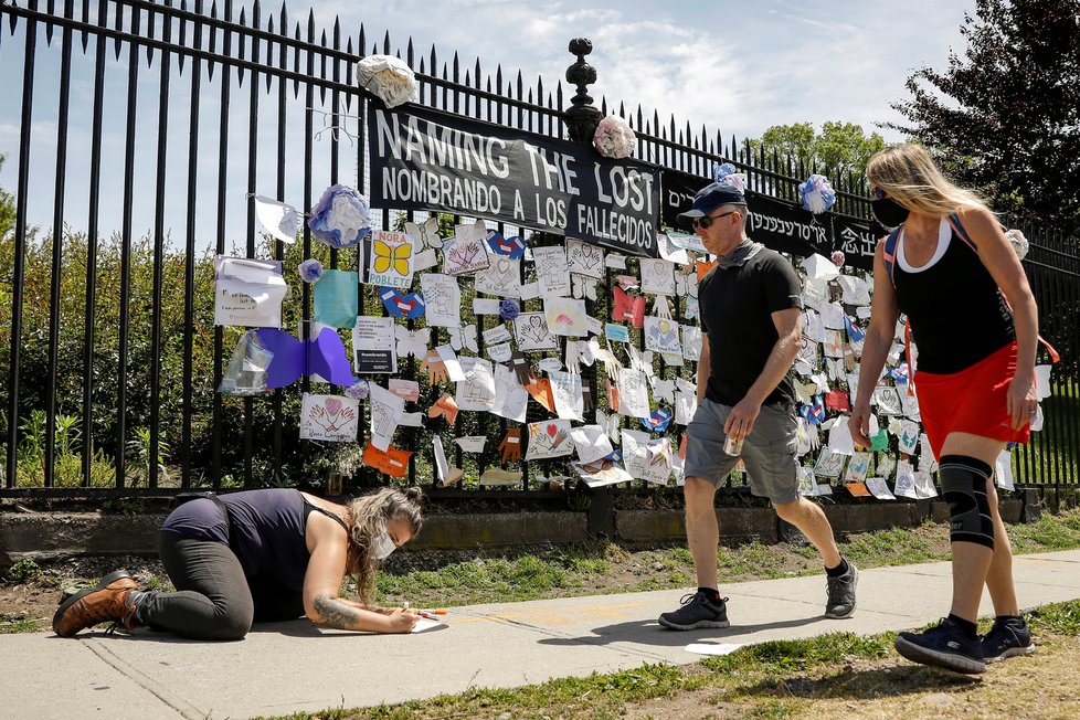 Lidé před hřbitovem v New Yorku přidávají vzkazy pro oběti koronaviru (27. 5. 2020)