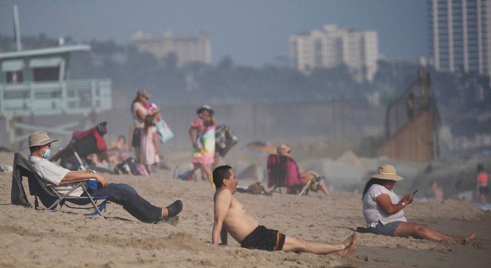 Lidé v Americe si užívají na plážích, někteří nosí roušky.