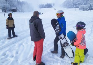 Správce Ski areálu v Olešnici František Jílek (zády) lyžařům vysvětluje, že kvůli nařízení vlády na hlavní sjezdovku nesmějí.