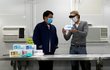 V hongkongské továrně na obličejové roušky se zaměstnanci nezastaví