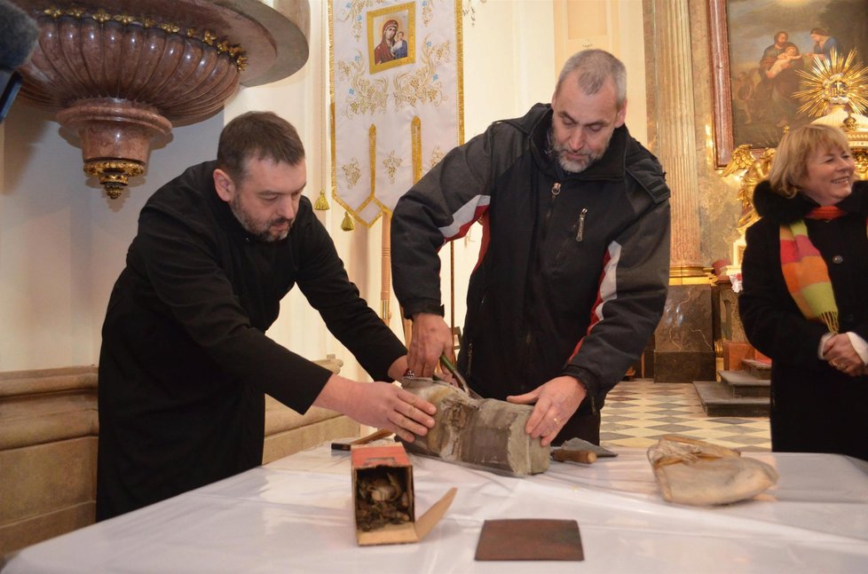 Muzejníci pod dohledem představeného chrámu Sergije Mackuly stříhají olověnou a pozinkovanou schránku, ukrývající 300 let staré relikvie.