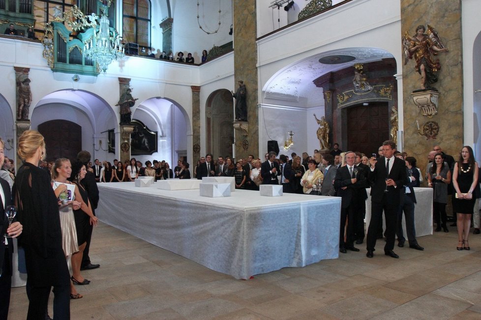 Odsvěcený kostel sv. Šimona a Judy s bílými stoly v prostoru, které tanečnicím posloužily jako molo a posléze se proměnily v tabule plné lahůdek.