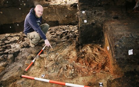 Archeolog Miroslav Dejmal ukazuje kostry tří násilně usmrcených lidí.