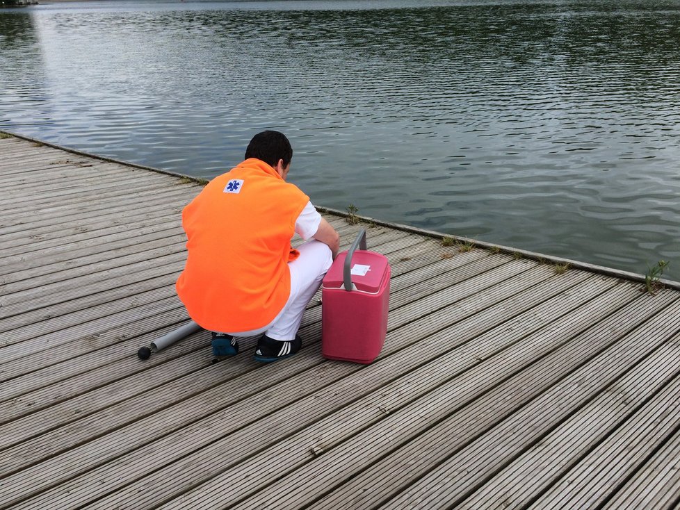 Pracovník Státního zdravotního ústavu se připravuje k odběru vzorku vody.