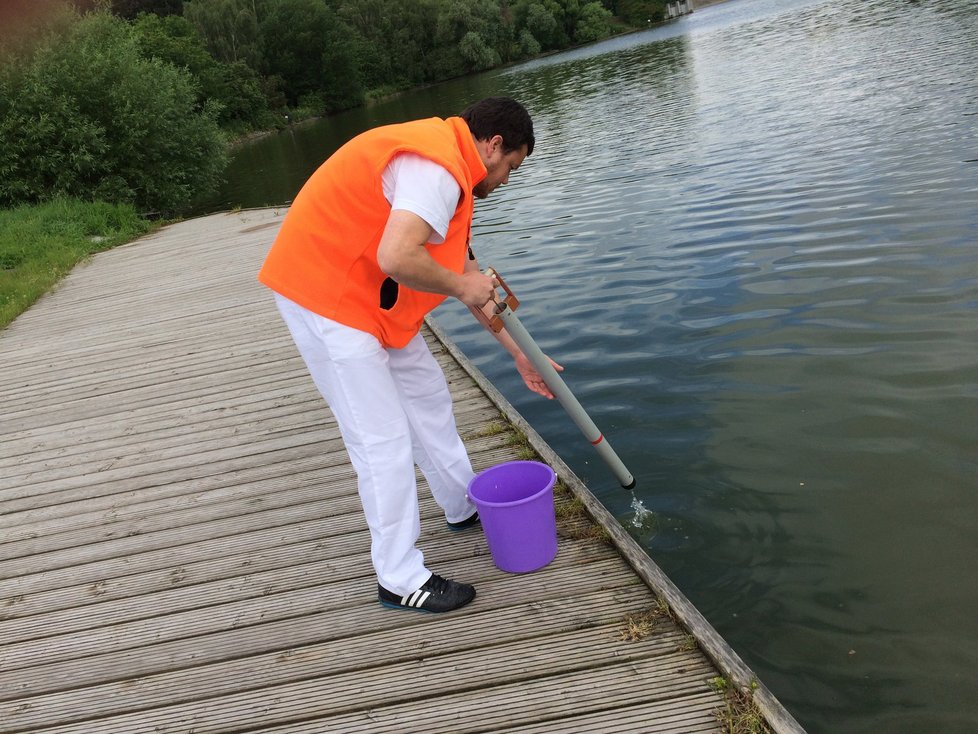 Pracovník Státního zdravotního ústavu odebírá vodu z přehrady Hostivař.