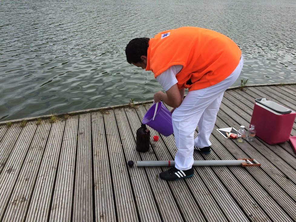 Pracovník Státního zdravotního ústavu připravuje vzorky vody z přehrady k převozu.