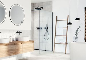 Bílý základ s kontrastními černými liniemi a hřejivými dřevěnými prvky je zaručený recept na nadčasovou koupelnu.