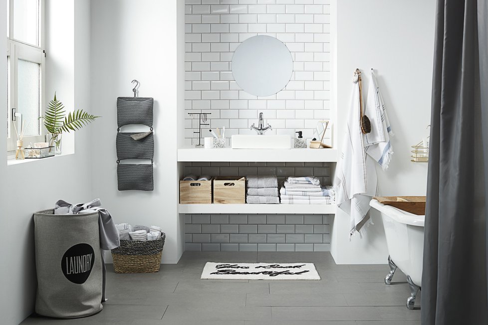 Toužíte po koupelně ve skandinávském stylu? Pak byste neměli vynechat bílé obdélníkové obkládačky, šedé plochy a dřevěné detaily.