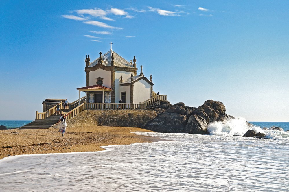 Kostelík Capela do Senhor da Pedra stojí přímo na pláži kousek  na jih od Porta