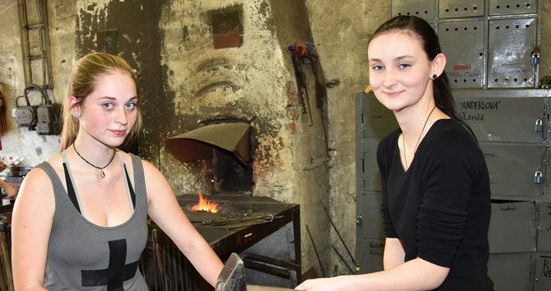 Simona Holá (vlevo) a Kateřina Slámová prodlužují železný materiál tak, že ho nahřejí a kladivy do něj buší.
