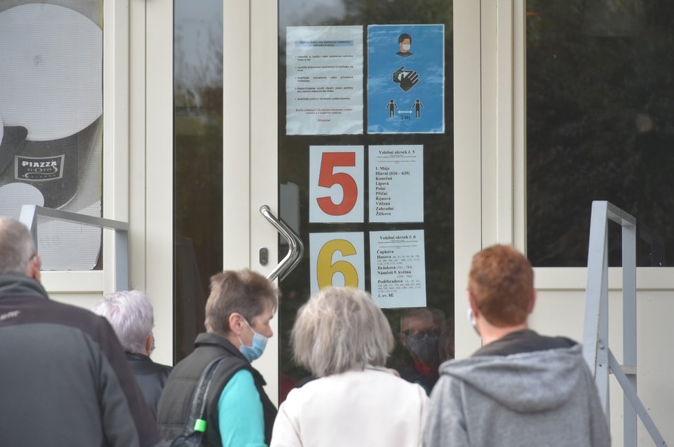 Volby do krajských zastupitelstev a třetiny senátu začaly ve 14 hodin. Volilo se také v Chodově na Karlovarsku. Lidé tam zároveň vyjadřovali v místním referendu svůj názor na výstavby nákupního centra. Na snímku je skupina voličů před volební místností ve vestibulu kina (2. 10. 2020)