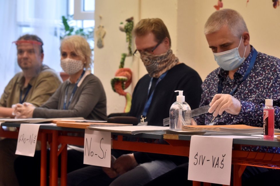 Členové volební komise chránící se proti nákaze koronavirem, ve volební místnosti v Ostravě (2. 10. 2020)
