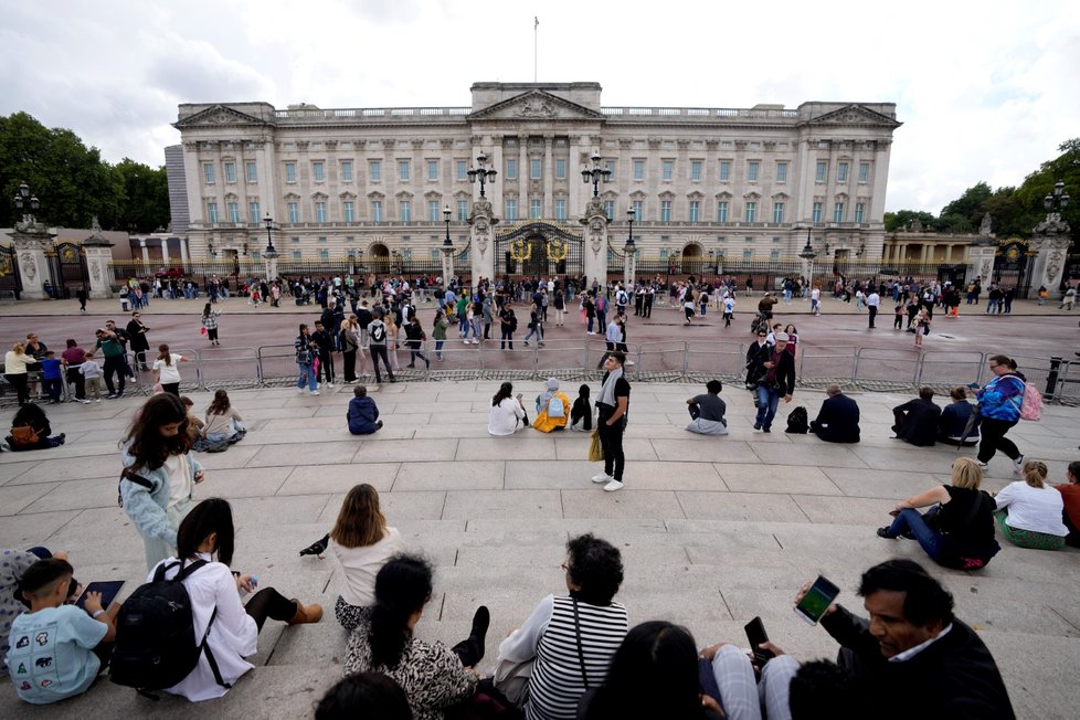 Lidé se shromažďují u Buckinghamského paláce.