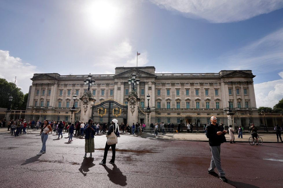 Lidé se shromažďují u Buckinghamského paláce.