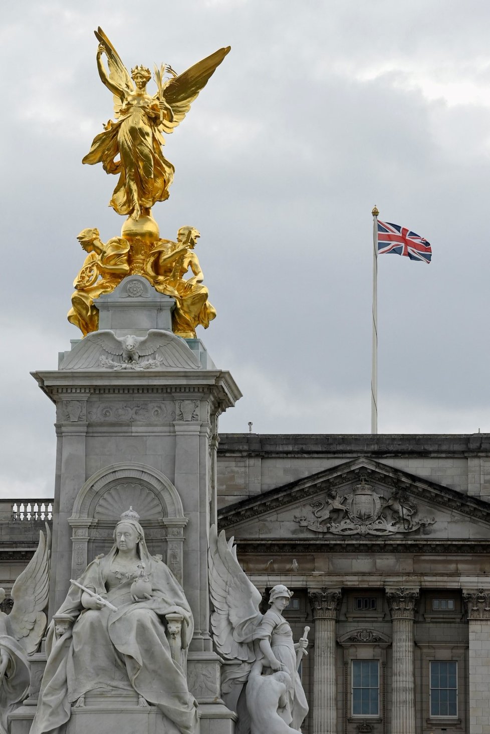 Lidé se shromažďují u Buckinghamského paláce.