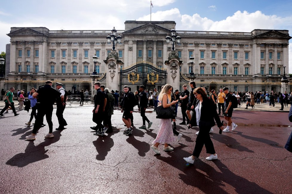 Lidé se shromažďují u Buckinghamského paláce.