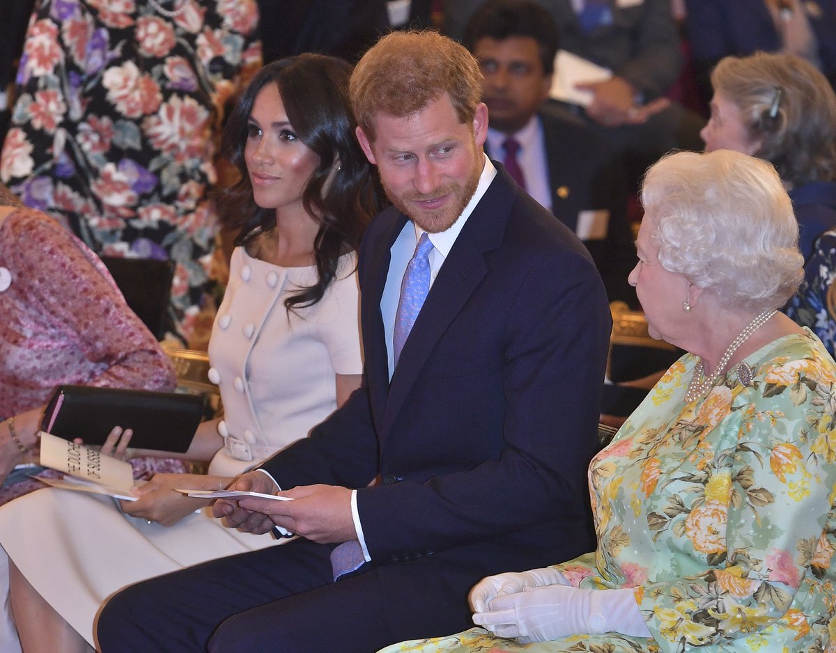 Královna Alžběta II. v doprovodu vnuka prince Harryho a jeho chotě Meghan.