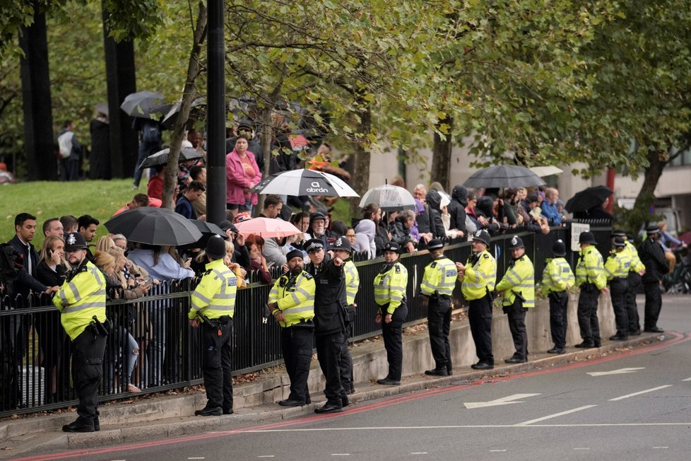 Policie dohlíží na davy čekající na rakev s královnou u Buckinghamského paláce.