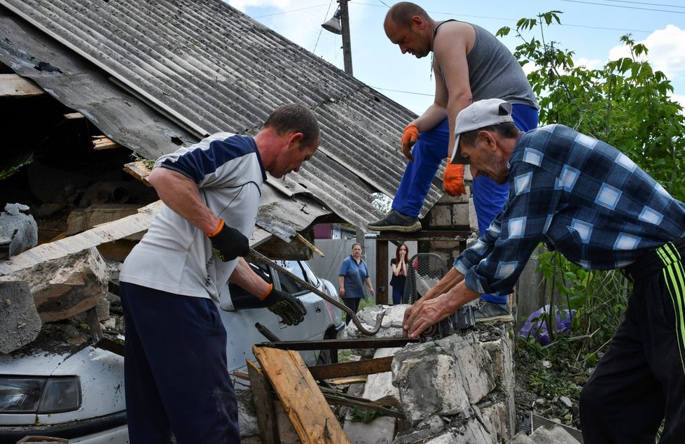 Obyvatelé Kramatorsku odklízejí trosky po ruském útoku. (25. 5. 2022)