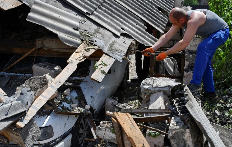 Obyvatelé Kramatorsku odklízejí trosky po ruském útoku. (25. 5. 2022)